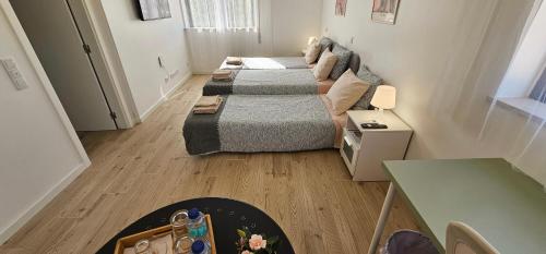 two beds in a small room with a table at Ideal Bubble House in Faro