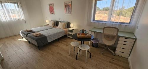 a bedroom with a bed and a desk and a table at Ideal Bubble House in Faro