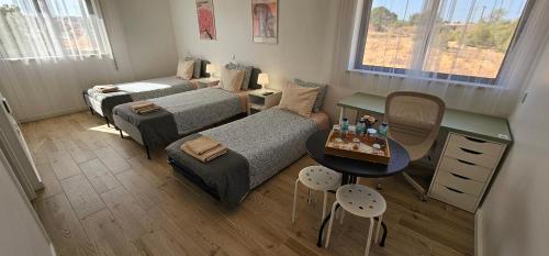 a small room with two beds and a table with a table at Ideal Bubble House in Faro