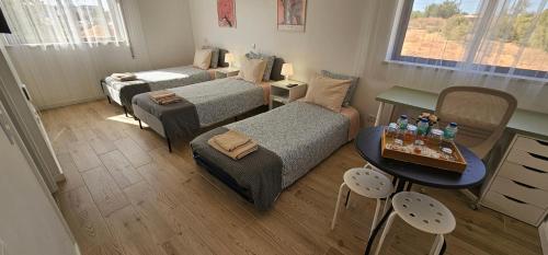 a small room with two beds and a table with a tableablish at Ideal Bubble House in Faro