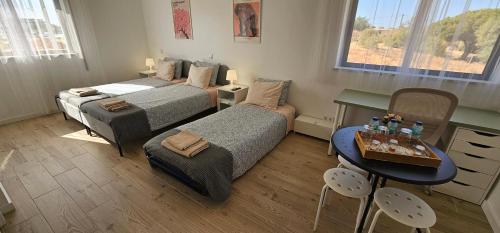 a bedroom with two beds and a table and a desk at Ideal Bubble House in Faro