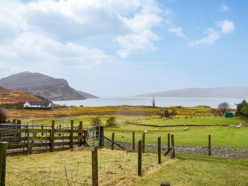 une clôture dans un champ avec vue sur l'eau dans l'établissement The Cottage, à Ollach