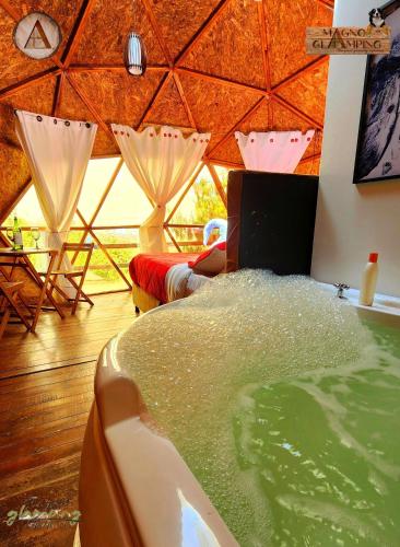 a room with a hot tub and a bed in a tent at Magno Glamping Combita in Cómbita