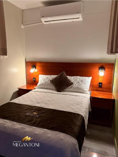 a bedroom with a large bed and two night stands at Grand Hotel Megantoni in Quillabamba