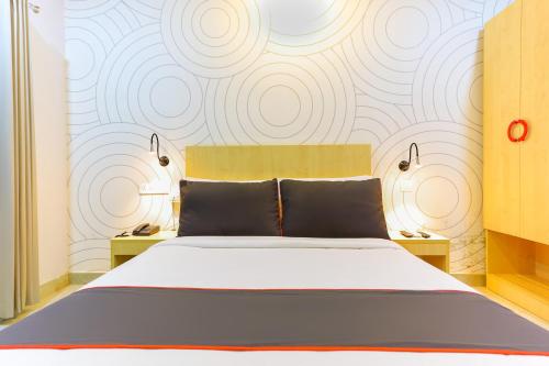a bedroom with a large bed and a wall at Super Collection O Marhaba Govindapuram in Calicut