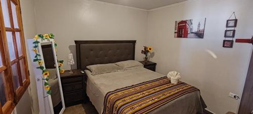 a bedroom with a bed and a dresser with flowers on it at La casa de Silvana in San Pedro de Atacama