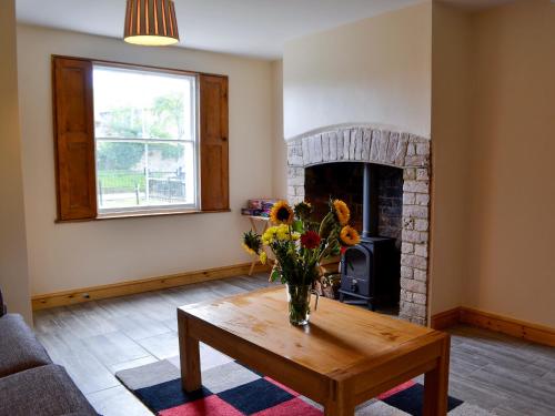 ein Wohnzimmer mit einer Vase mit Blumen auf einem Tisch in der Unterkunft 4 Greenhaye Cottages - Uk31236 in Newnham
