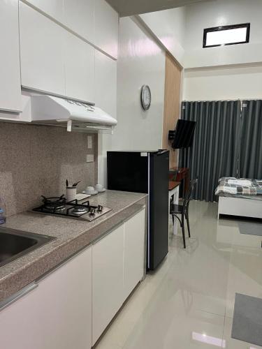 a kitchen with a stove and a counter top at DADOORS Apartment in Iloilo City