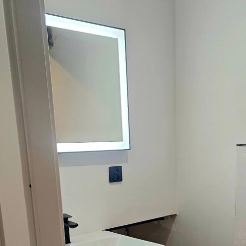 a bathroom with a mirror and a sink at Apartament Contandair in Olsztyn