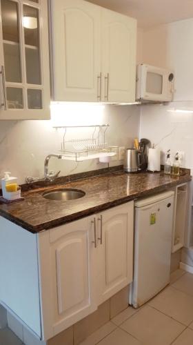 a kitchen with white cabinets and a sink at Monoambiente céntrico in Montevideo