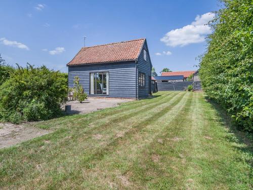 a blue house with a large yard in front of it at Butler's Barn in Darsham