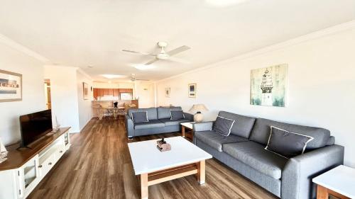 a living room with a couch and a tv at Breakers 2 - 7, 18 - 20 Pacific Parade in Yamba