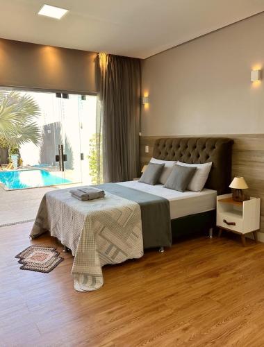 a bedroom with a large bed and a large window at Rancho Palmeira in Formosa