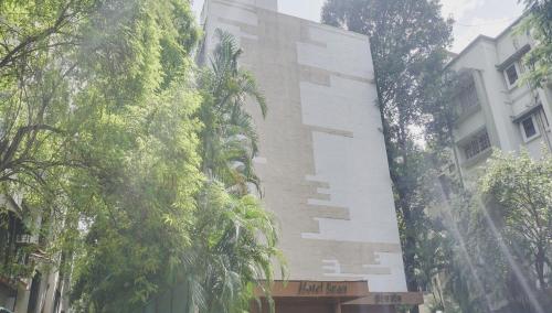 a tall building with trees in front of it at Hotel O Span Executive in Pune