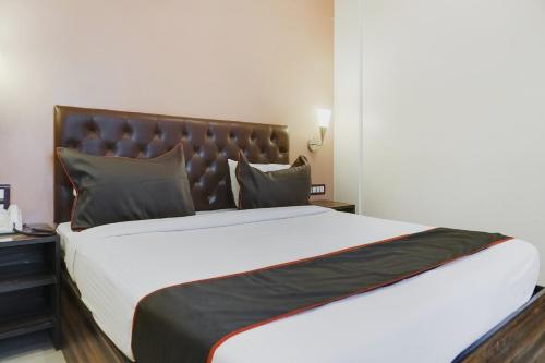 a bedroom with a large bed with a leather headboard at Hotel O Span Executive in Pune