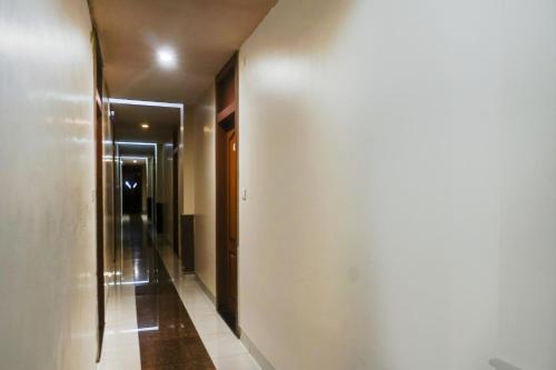 a hallway with a white wall and a hallway with a door at Hotel O Span Executive in Pune
