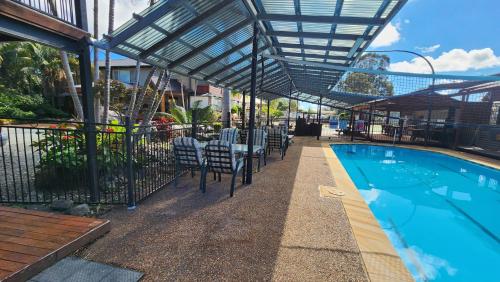 a patio with chairs and a swimming pool at T's Resort & Motel in Port Macquarie