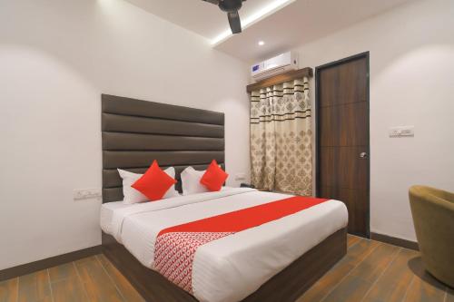 a bedroom with a large bed with red pillows at Hotel O Rudraksh in Indore