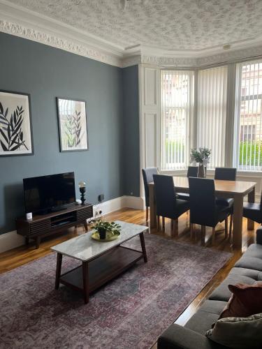 a living room with a couch and a table at 3BR Apt Near Ibrox Subway Sleeps 7 and Parking in Glasgow