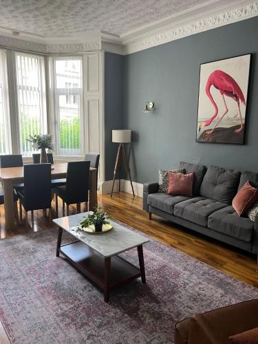 a living room with a gray couch and a table at 3BR Apt Near Ibrox Subway Sleeps 7 and Parking in Glasgow