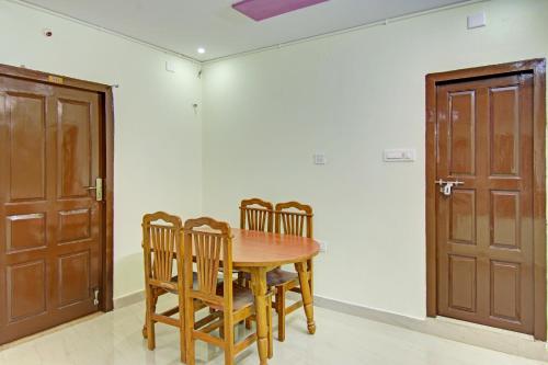 a dining room with a wooden table and chairs at Hotel O Sea Coastal in Kākināda