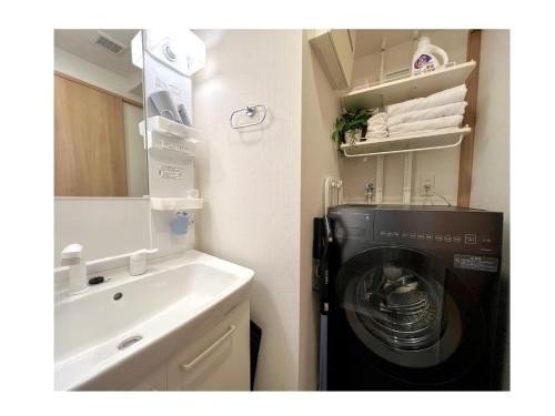 y baño con lavadora junto a un lavabo. en Generous Forest 101, en Tokio