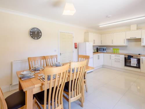 a kitchen and dining room with a wooden table and chairs at Dawson Park 6 - Uk12665 in Mablethorpe
