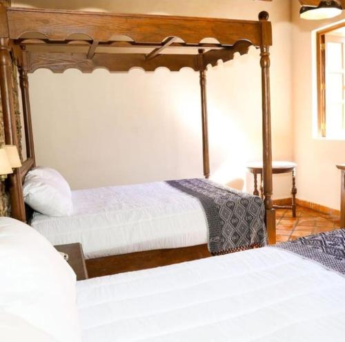 a bedroom with two beds with white sheets at Hotel San Francisco Tlaxcala in Tlaxcala de Xicohténcatl