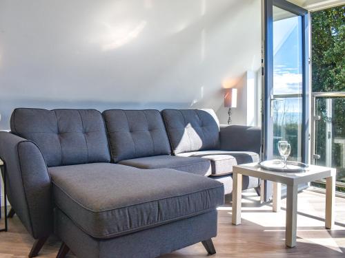a living room with a blue couch and a table at Sunny South Lodge in Sandown