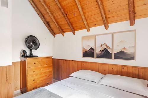 a bedroom with a bed and a wooden ceiling at Chalé Montserrat com Lareira e Vista para as Montanhas in Nova Friburgo