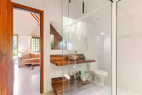 a bathroom with a glass shower and a toilet at Chalé Montserrat com Lareira e Vista para as Montanhas in Nova Friburgo