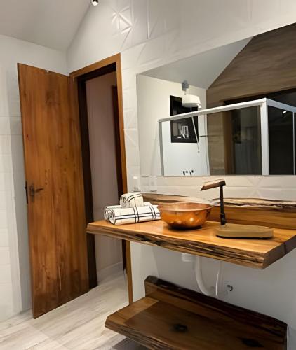 a bathroom with a sink and a bowl on a counter at Chalé Montserrat com Lareira e Vista para as Montanhas in Nova Friburgo
