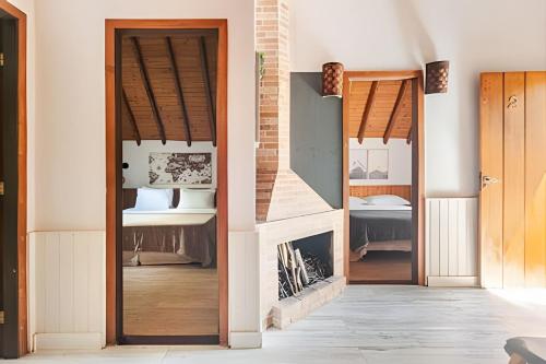 a living room with a fireplace and wooden doors at Chalé Montserrat com Lareira e Vista para as Montanhas in Nova Friburgo