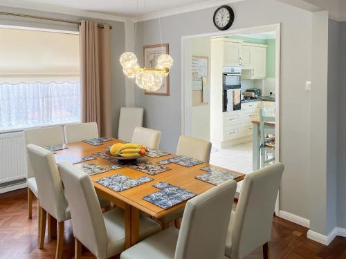 a dining room with a wooden table and chairs at The Fairway in Westgate on Sea