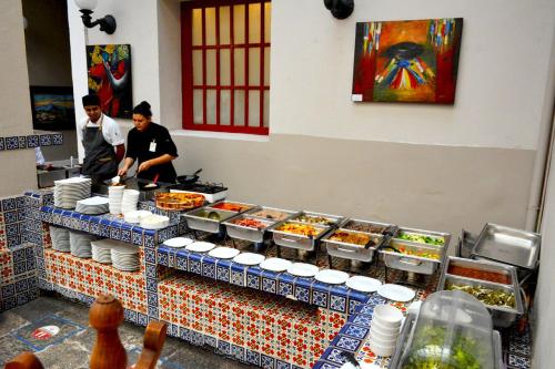 two men preparing food in a restaurant kitchen at Hotel San Francisco Tlaxcala in Tlaxcala de Xicohténcatl