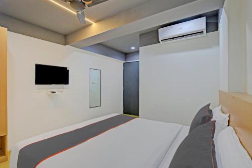 a bedroom with a bed and a tv on the wall at Collection O De'pearl Hotel in Surat