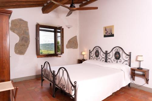 ein Schlafzimmer mit einem weißen Bett und einem Fenster in der Unterkunft Große Ferienwohnung in Rapale mit Terrasse, Grill und gemeinsamem Pool in Rapale