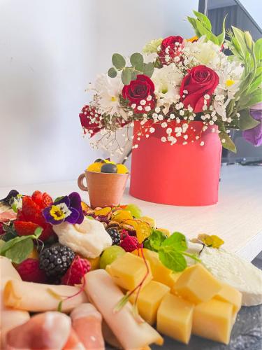 a table with a plate of cheese and a vase of flowers at Hotel San Francisco Tlaxcala in Tlaxcala de Xicohténcatl