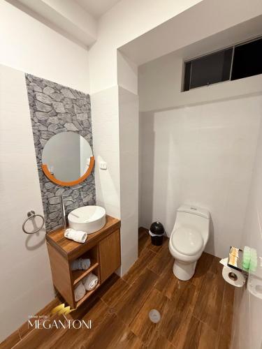 a bathroom with a white toilet and a mirror at Grand Hotel Megantoni in Quillabamba