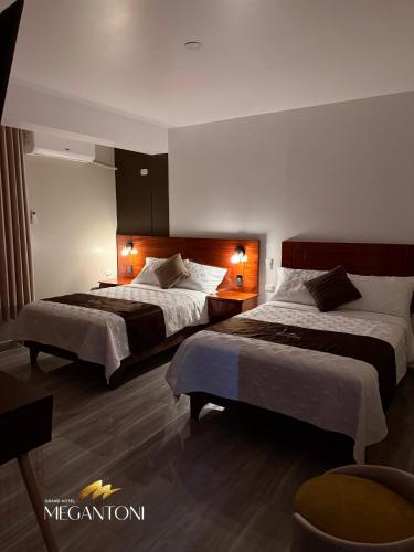a hotel room with two beds with lights on them at Grand Hotel Megantoni in Quillabamba