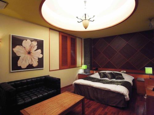 a bedroom with a bed and a large ceiling at ホテルキャットハウス門真店 in Osaka