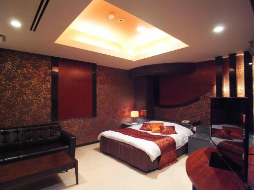 a hotel room with a bed and a couch at ホテルキャットハウス門真店 in Osaka