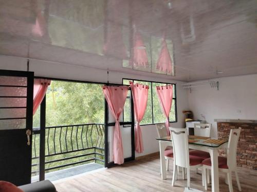 a dining room with a table and chairs and a balcony at Casa campestre in Fresno