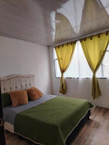a bedroom with a bed and a window with yellow curtains at Casa campestre in Fresno