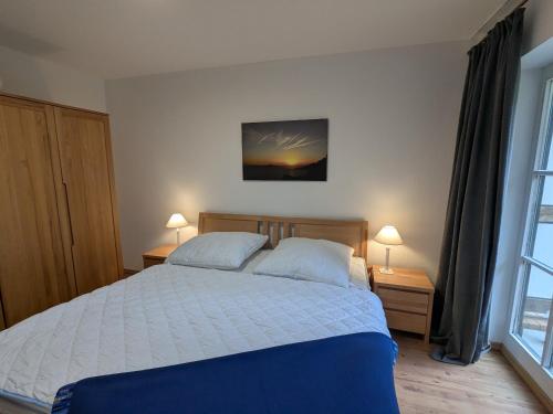 Un dormitorio con una cama y dos lámparas y una ventana. en Rasmus, en Born