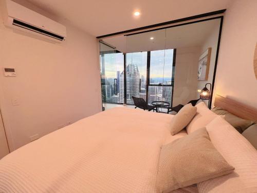 Un dormitorio con una cama grande y una ventana grande en Melbourne's Premium on Spencer, en Melbourne