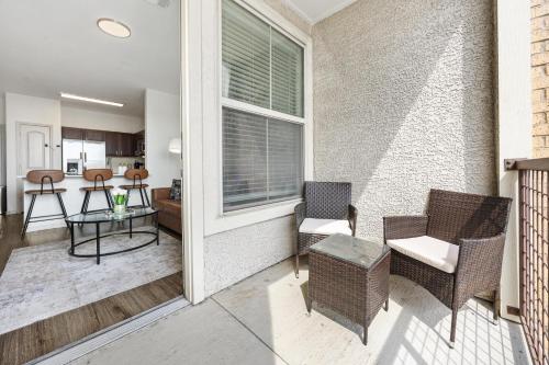 a balcony with chairs and a table and a kitchen at Chic 1BR Frisco Stay, King & Sofa, Pool & Gym in Frisco