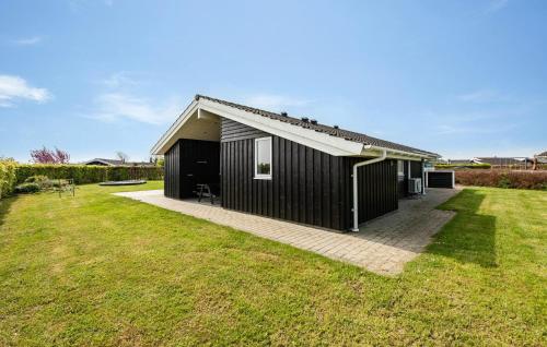 a black house with a large grass yard at Holiday Home Chr Jacobsensvej in Årøsund