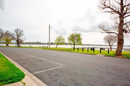 an empty parking lot next to a body of water at Arnie's Place in Yarrawonga