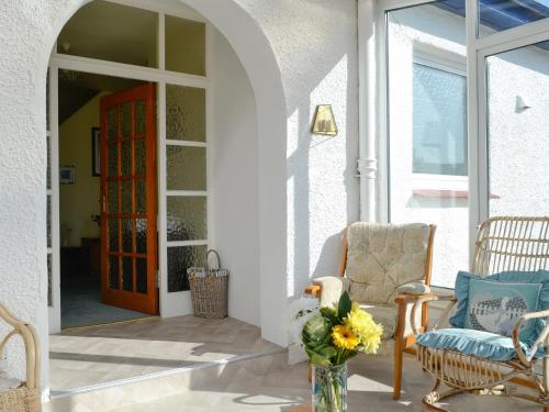a front door of a house with a vase of flowers at Bel-Mar in Whithorn